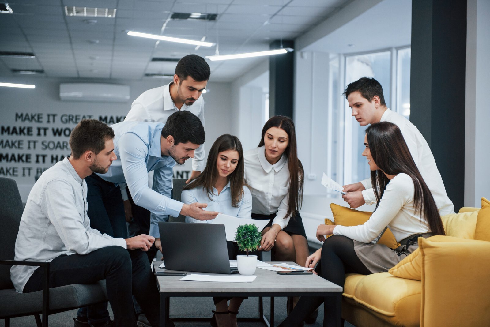 Team of young professionals reviewing a business document together in the office