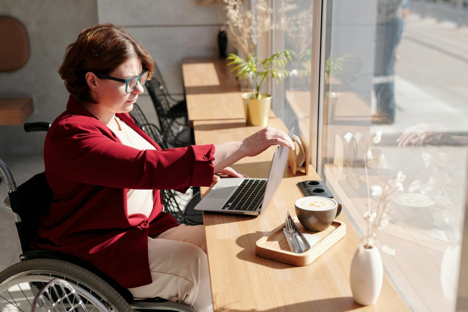 Café owner reviewing bookkeeping records on a laptop over coffee